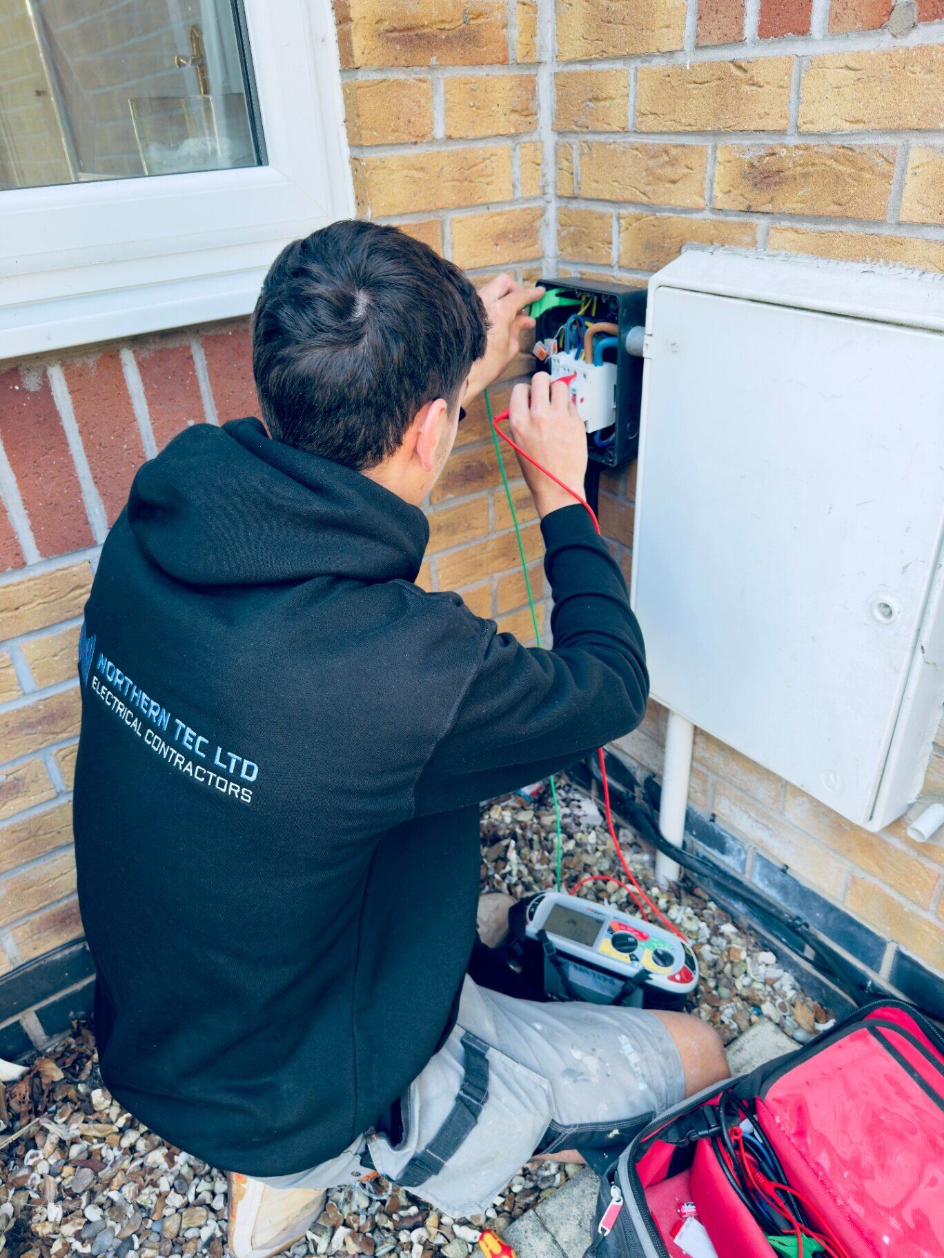 Northern Tec electrician carrying out periodic electrical inspection and testing on an external meter cabinet