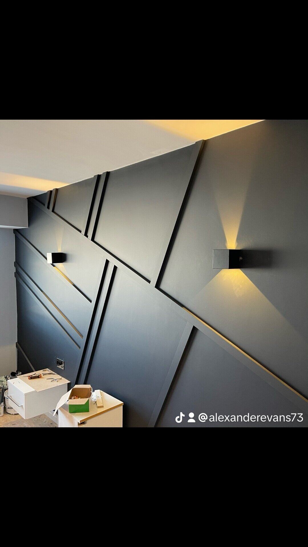 Bespoke geometric panelled feature wall with up-down LED wall lights installed by Northern Tec