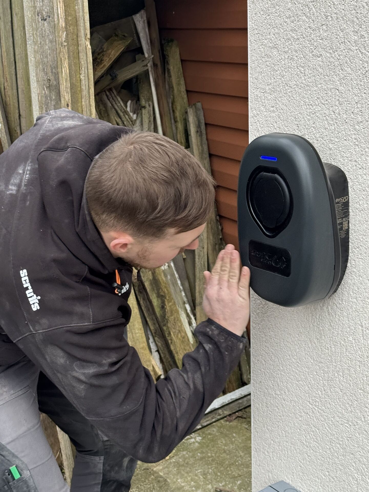 Close-up of a domestic EV charger with weatherproof socket cover